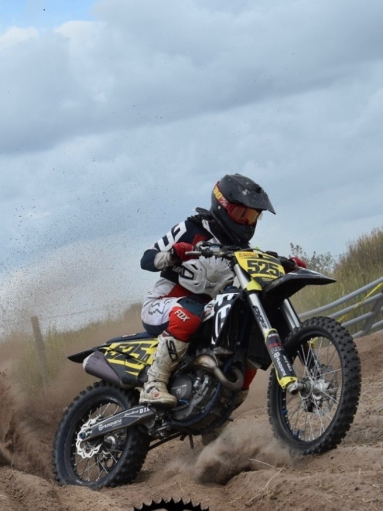a man riding a motorcycle down a dirt road