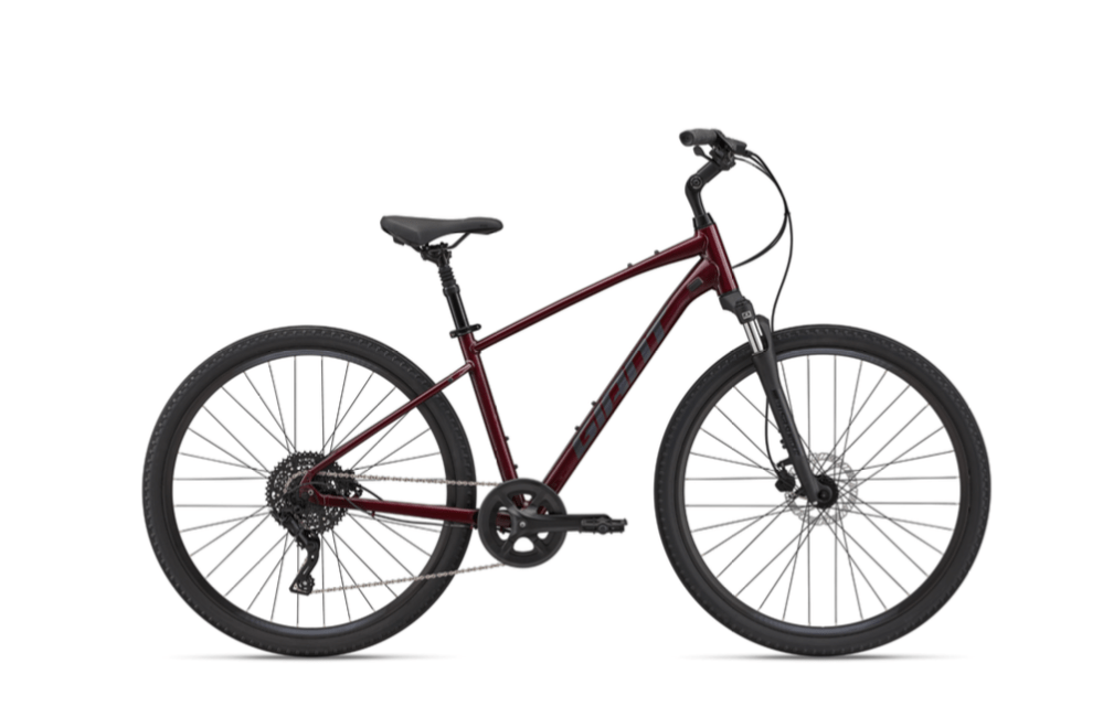 Red mountain bike with a black seat and large tires, viewed from the side.