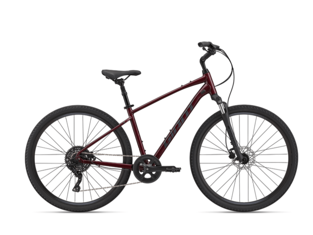 Red mountain bike with a black seat and large tires, viewed from the side.