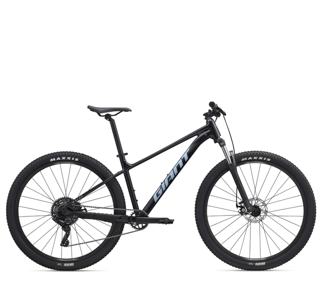 Black mountain bike with large tires and blue branding on frame, viewed from the side.